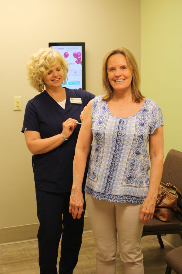 registered-nurse-treating-allergy woman blowing nose allergy cold disease flu Columbia allergy and Asthma Specialists in Columbia MO